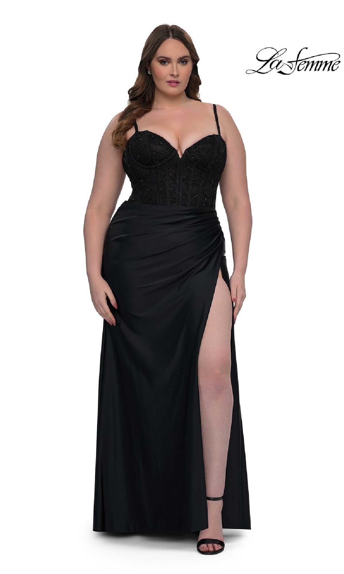 A woman in the La Femme 32449 plus-size long corset prom dress with a black draped skirt, thigh-high slit, and thin straps stands facing forward. The